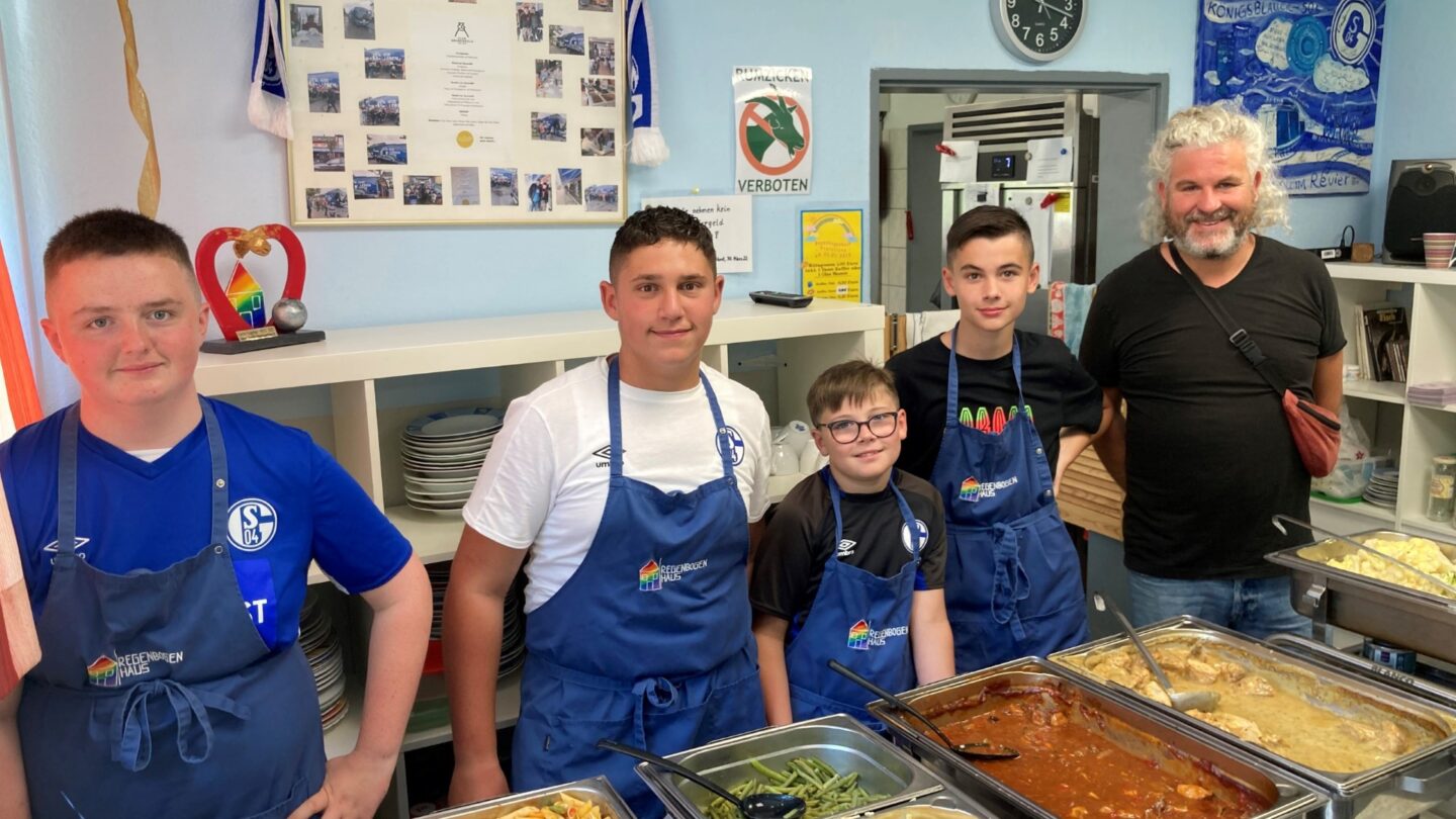 In ihrer Freizeit kicken Finn, Kenan, Fabrice und Louis regelmäßig auf den Bolzplätzen von Schalke hilft! – gefördert durch die RAG-Stiftung. Im Juli engagierten sich die vier abseits des Platzes und halfen tatkräftig bei der Essensausgabe im Gelsenkirchener Regenbogenhaus mit.