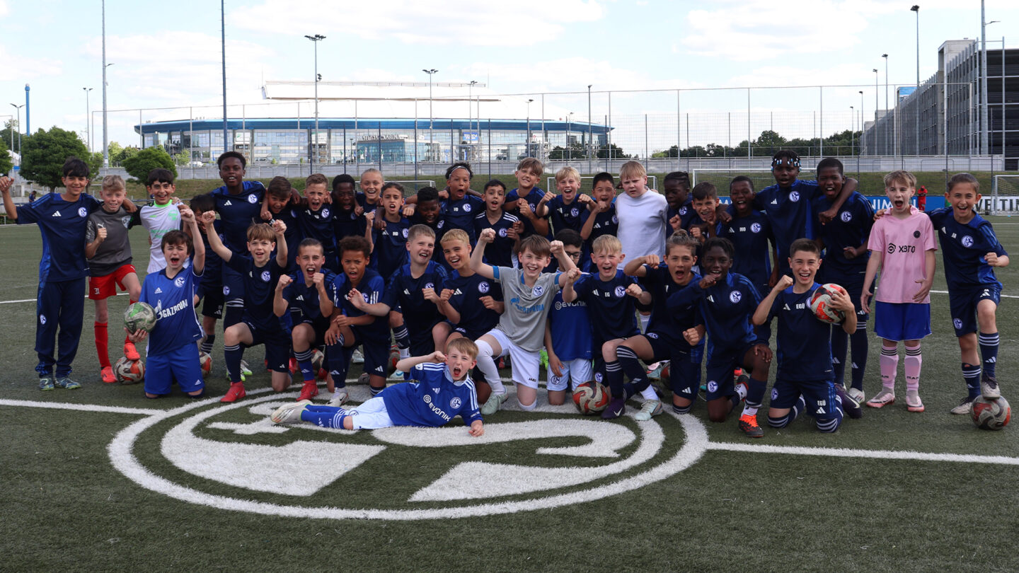 Gruppenfoto von Kindern und Trainern auf dem Fußballplatz