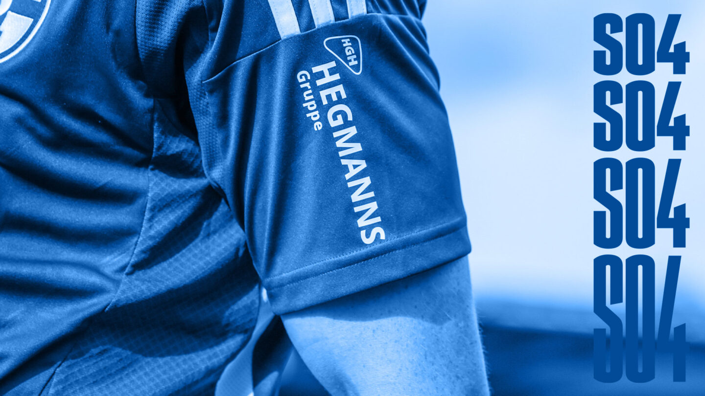 The HEGMANNS Group logo on the sleeve of a Schalke shirt.