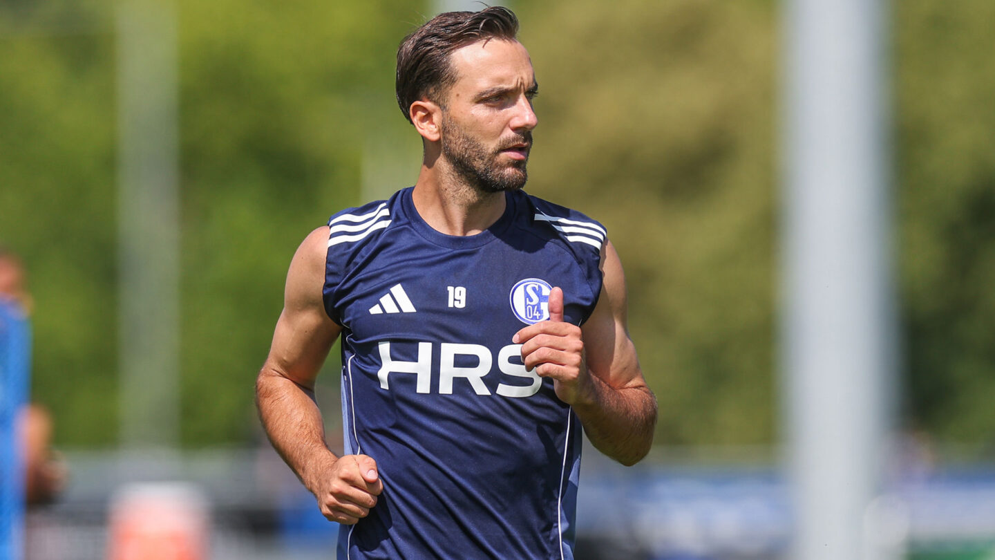Kenan Karaman läuft im Schalke-Training. Dabei trägt er ein Oberteil mit dem, Schriftzug von Partner HRS.