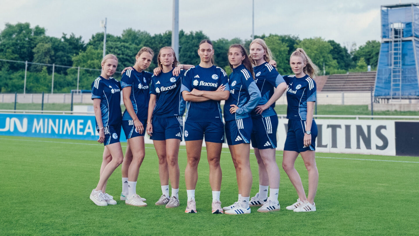 Sieben Spielerinnen des Schalker Frauen-Teams posieren in der neuen Trainingskleidung mit dem Schriftzug von flaconi auf dem Plaz.