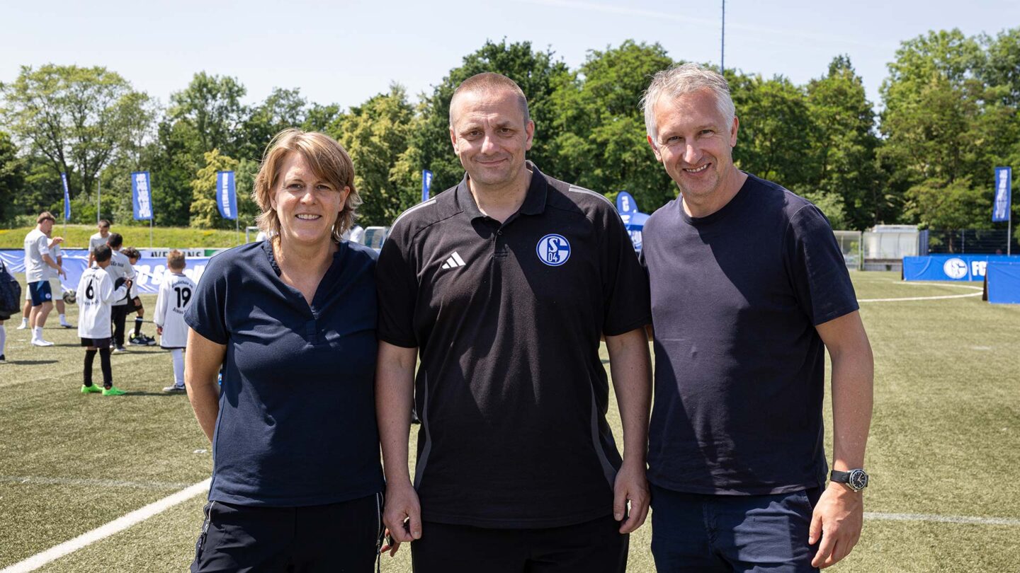 Christina Rühl-Hamers, Boris Liebing und Frank Baumann stehen vor dem Rasenplatz.