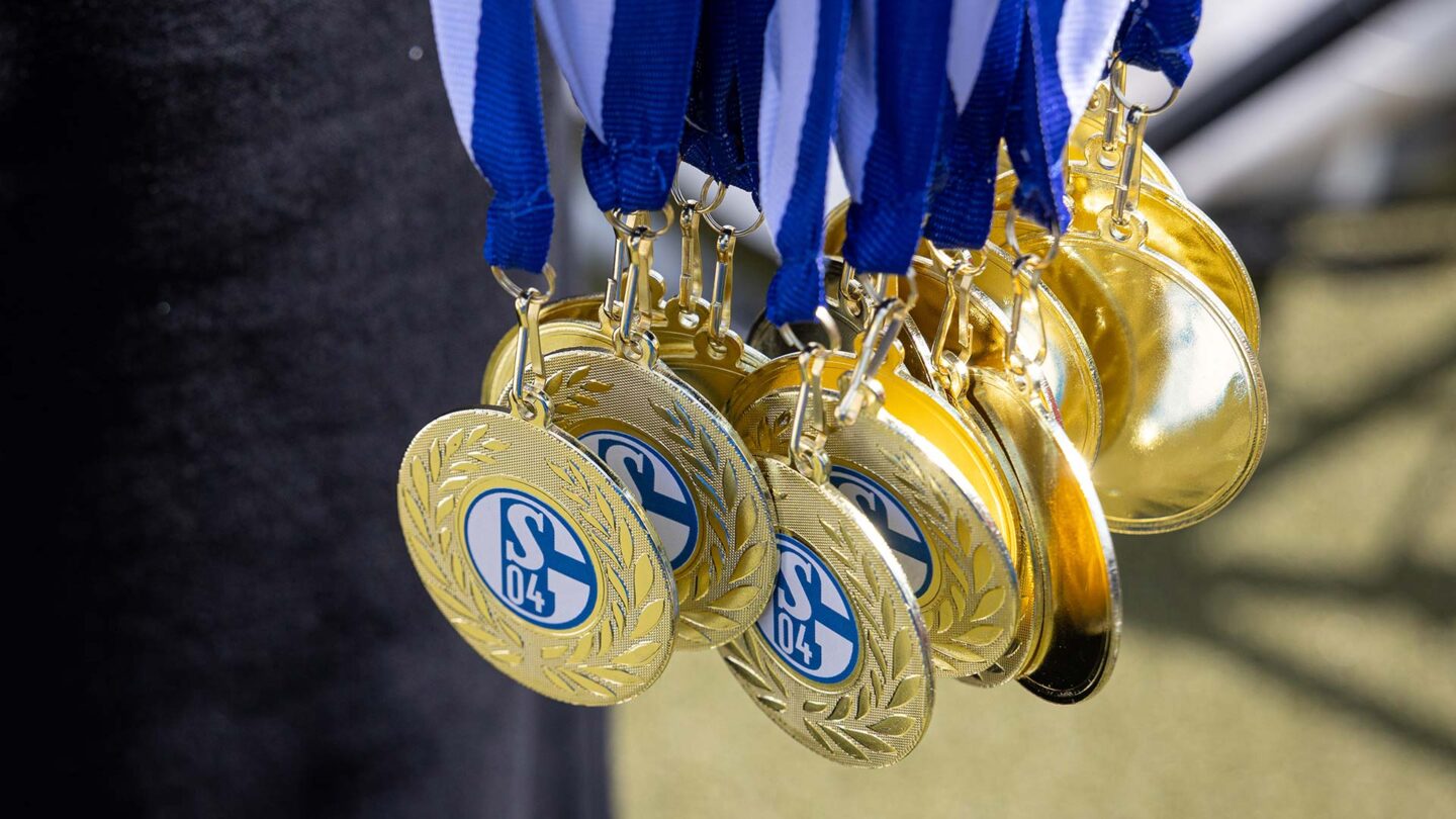 Viele S04-Medaillen hängen an Bändern.