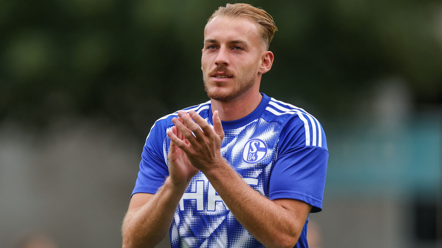 Timo Becker klatscht. Dabei trägt er ein Aufwärmshirt.