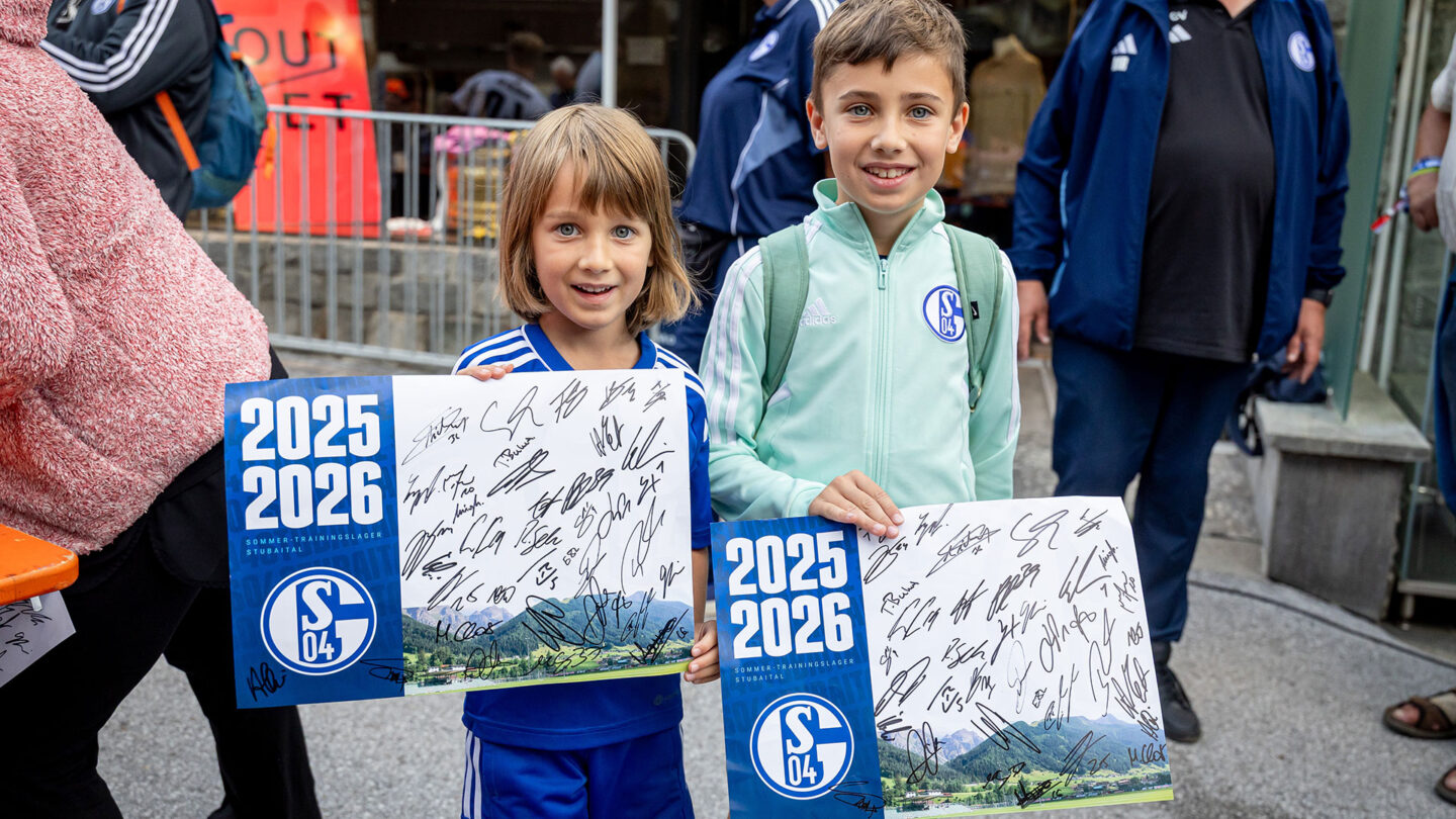 Zwei junge Fans präsentieren ihre gesammelten Autogramme.