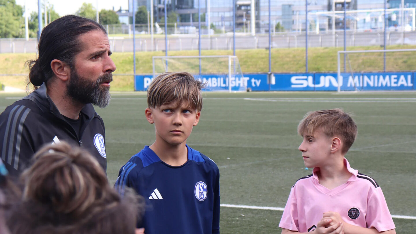 Trainer erklärt Kindern eine Übung